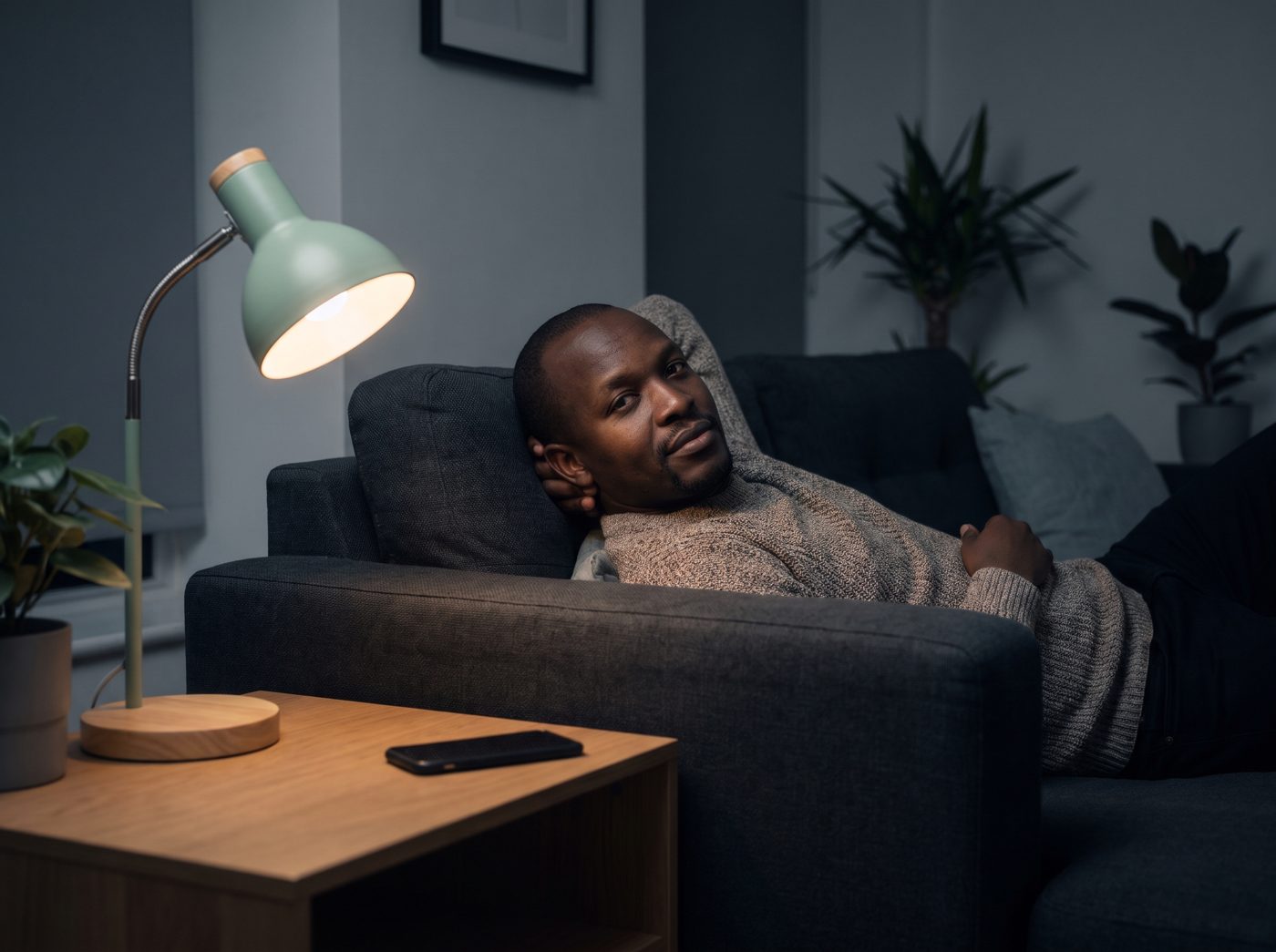 A shop owner resting at home in the evening with his phone on the table
